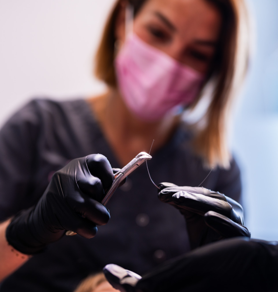 Le Docteur Py prépare le fil de contention à poser